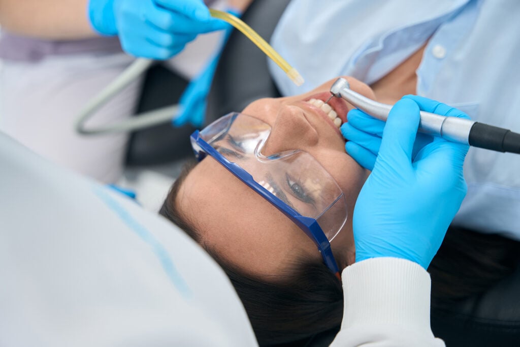 Stomatologist Treating Teeth To Female Client In Protective Glasses Sedation